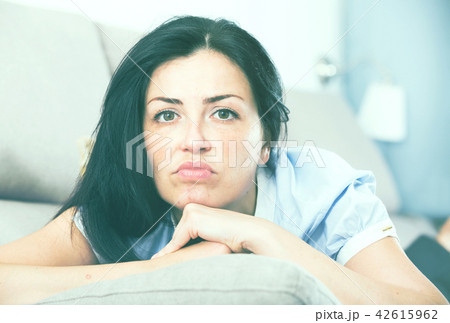 Young sad woman lying on cozy sofa 42615962