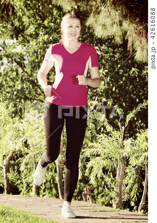Young girl in pink T-shirt is jogging Young girl in pink T-shirt is jogging 42616088