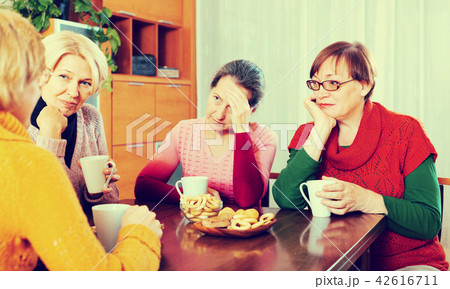 sad senior female friends drinking coffee sad senior female friends drinking coffee 42616711