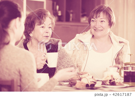 Senior women talking with girl while tea drinking 42617187