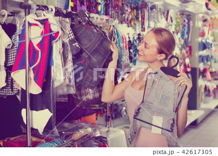 Female customer choosing clothes for dog Female customer choosing clothes for dog 42617305