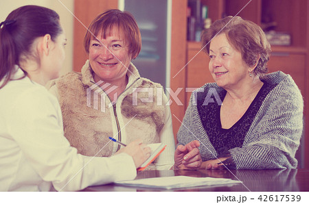 Female therapeutist consulting senior patients in clinic 42617539