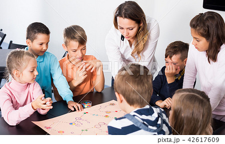 Children sitting at table with board game in classroom 42617609