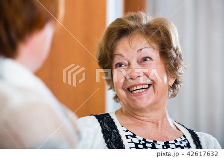 Relaxed female pensioners chatting and smiling indoor Relaxed female pensioners chatting and smiling indoor 42617632