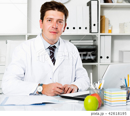 Dentist working in medical Center at the laptop 42618195