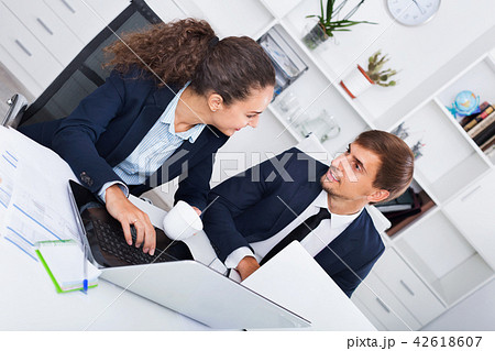 Two business male and female assistants wearing formalwear having work conversation 42618607