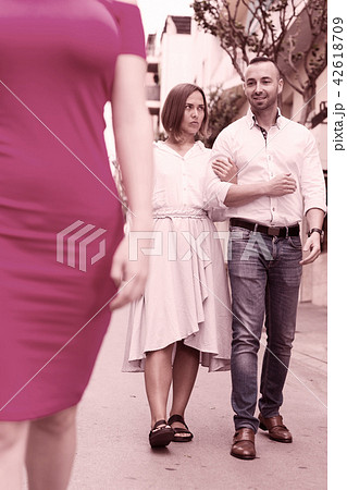 Man is fixing one is eyes on stranger woman and his girlfriend i 42618709