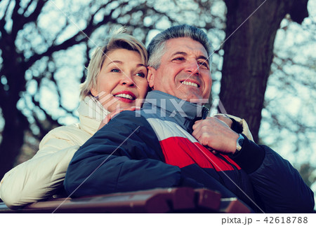 Smiling mature couple relaxing in park Smiling mature couple relaxing in park 42618788