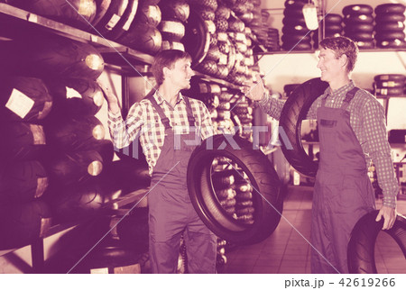 Two colleagues middle-aged working with motorcycle tires Two colleagues middle-aged working with motorcycle tires 42619266