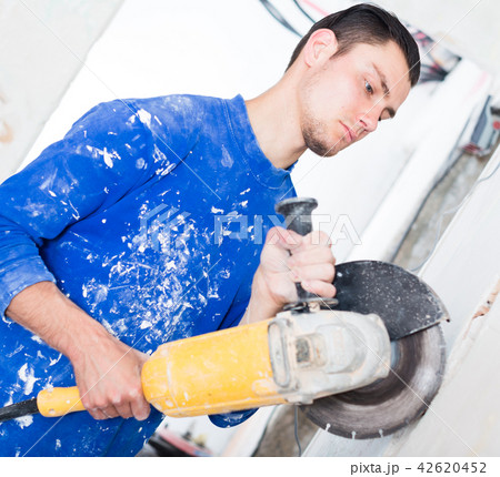 Male contractor using angle grinder 42620452