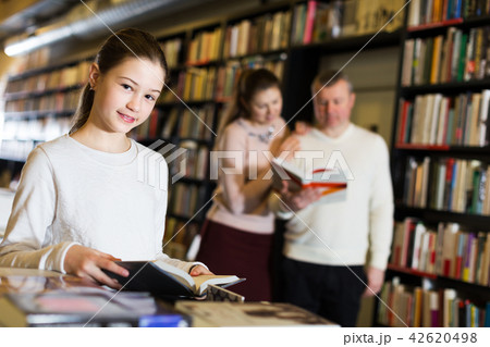 Girl choosing book with parents 42620498