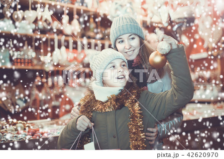 Young girl and her mother are choosing decorations for Christmas Young girl and her mother are choosing decorations for Christmas 42620970