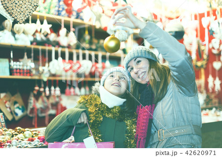 Smiling girl with woman are buying toys for X-mas tree Smiling girl with woman are buying toys for X-mas tree 42620971