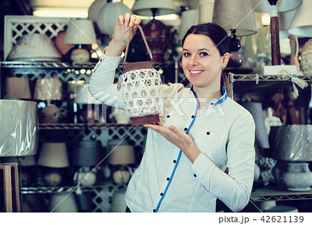 Woman demonstraiting lamp in store 42621139