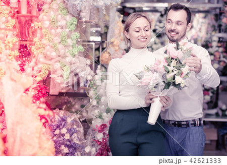 Couple choosing trendy flower decoration in store Couple choosing trendy flower decoration in store 42621333