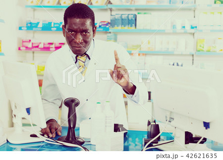 male pharmacist drawing attention of clients male pharmacist drawing attention of clients 42621635