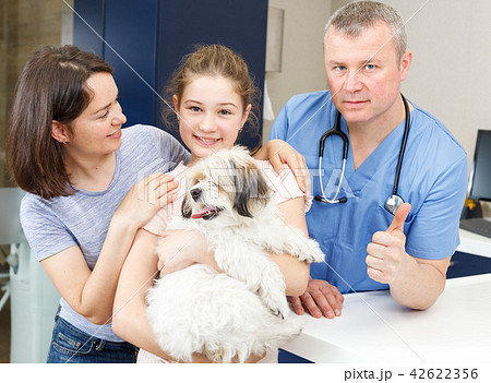 Happy family with dog consulting by veterinarian 42622356