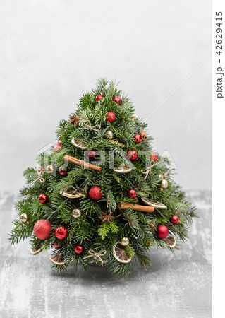 Christmas or New Year greeting card. Decorative fir. Pine branches, red balls, cinnamon sticks and 42629415