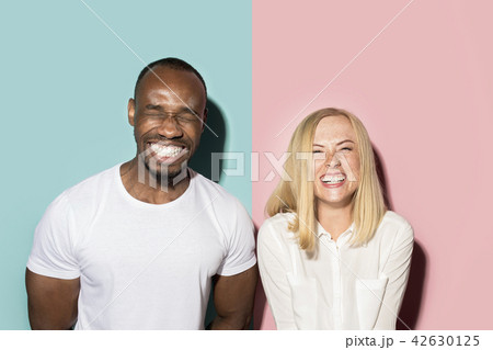 happy afro man and woman. Dynamic image of caucasian female and afro male model on pink studio. 42630125