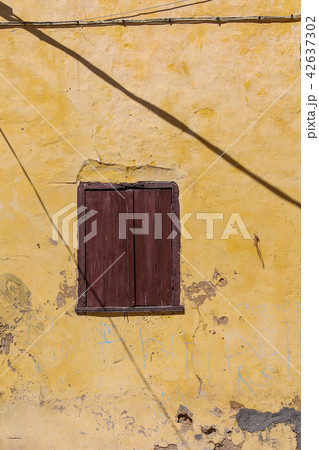 Window of an old house with a closed shutter 42637302