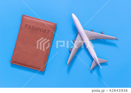 White toy plane and brown passprot cover on blue 42643936