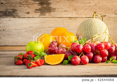 Many types of fruit placed on a wooden floor. 42644068