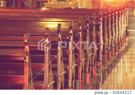 rows of empty old wooden pews in historic church 42644217