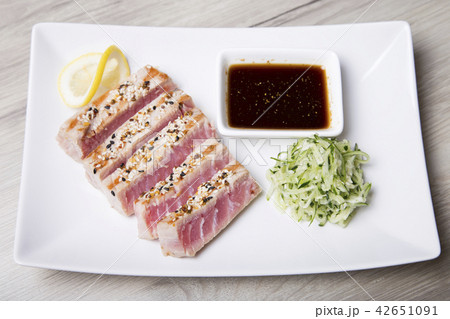 Grilled tuna with sesame seeds and cucumber salad Grilled tuna with sesame seeds and cucumber salad 42651091