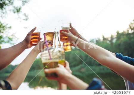 Bottles of beer in people's hands on blue sky background Bottles of beer in people's hands on blue sky background 42651677