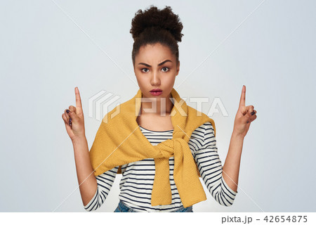 Young woman studio isolated in white pointing up with two hands  42654875