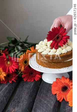 homemade layer cake and male hand decorating it homemade layer cake and male hand decorating it 42657146
