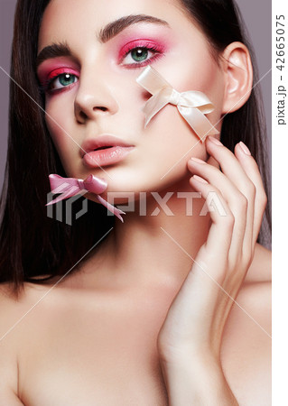 Girl with makeup and silk bow on the face Girl with makeup and silk bow on the face 42665075