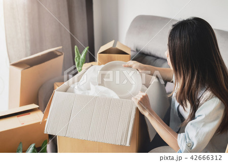 Young happy woman moving in new home Young happy woman moving in new home 42666312