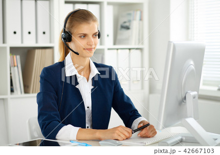 Modern business woman with headset in the office. Customer service operator at home work place 42667103