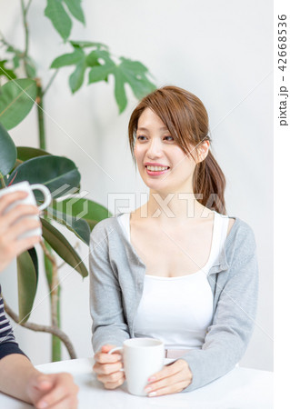 部屋で男性と会話する女性 42668536