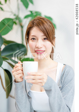 コーヒーカップを手にこちらを見つめる女性 42668538
