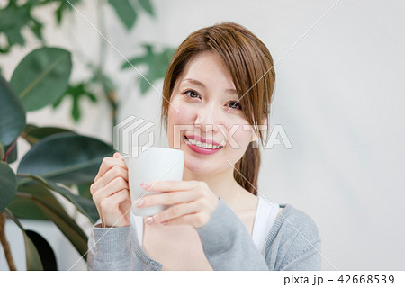 コーヒーカップを手にこちらを見つめる女性 42668539
