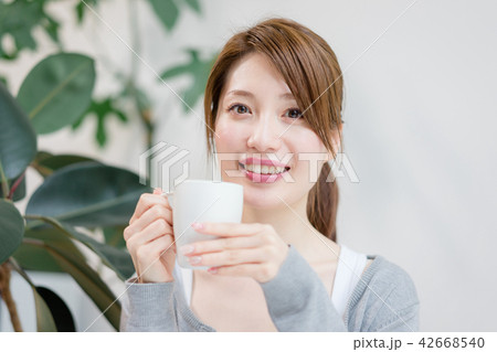 コーヒーカップを手にこちらを見つめる女性 42668540
