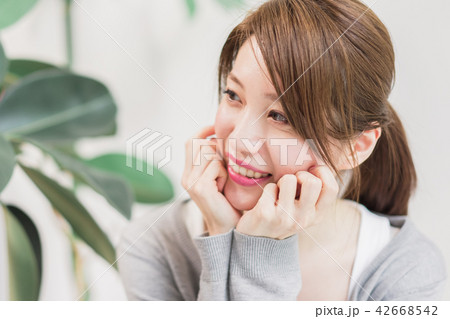 頬杖をついて甘えた目線で相手を見つめる女性 42668542