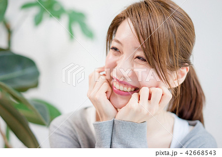 頬杖をついて甘えた目線で相手を見つめる女性 42668543