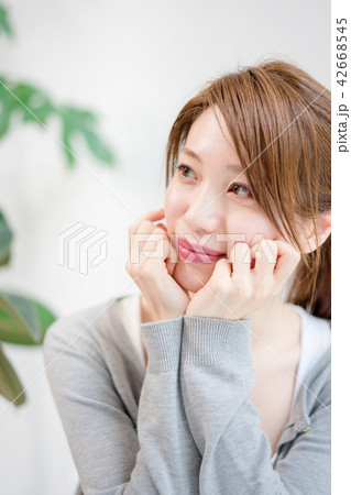 頬杖をついて甘えた目線で相手を見つめる女性 42668545
