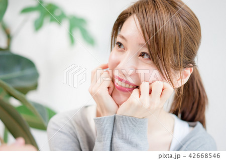 頬杖をついて甘えた目線で相手を見つめる女性 42668546