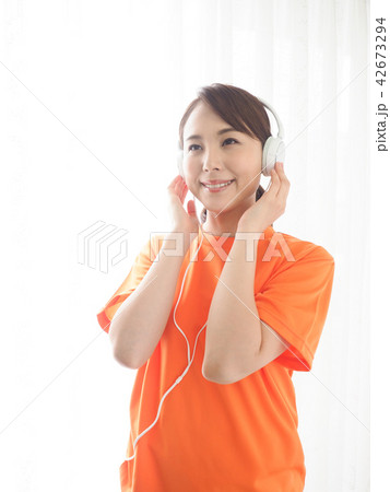白いヘッドホンで音楽を聴く女性 白いヘッドホンで音楽を聴く女性 42673294