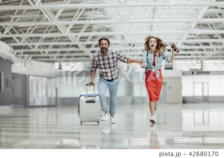Optimistic male and girl running with baggage 42680170
