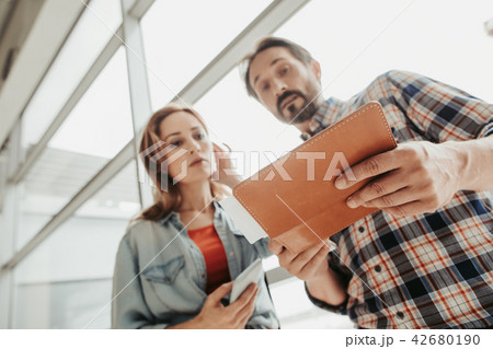 Calm man and girl looking at tickets 42680190