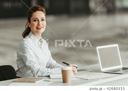 Outgoing lady situating at desk during job 42680353
