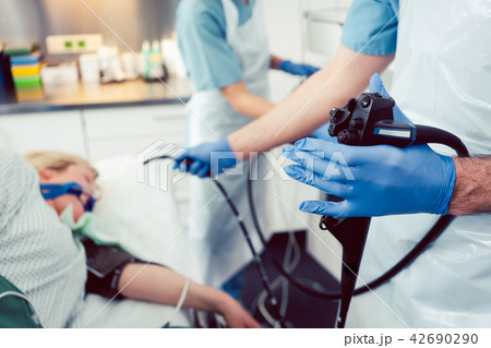 Doctor inserting camera of gastroscope into mouth of patient Doctor inserting camera of gastroscope into mouth of patient 42690290