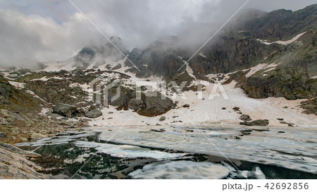 Small lake in thaw on Italian Alps  42692856