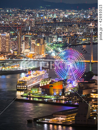 大阪港に停泊する豪華客船とベイサイドの夜景とレインボーの観覧車 縦構図 の写真素材