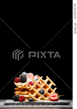 Photo of viennese wafers with fresh raspberries, strawberries sprinkled with powdered sugar on 42695078